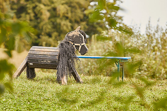 Holzpferd im Grünen als Spielzeug für Montessori Kinder