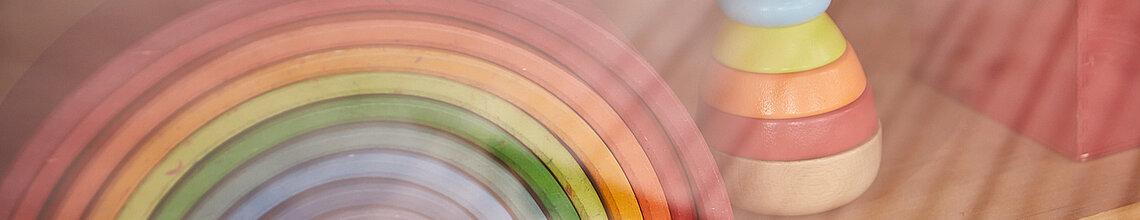 Bunter Holz-Regenbogen und -Figur im Regal