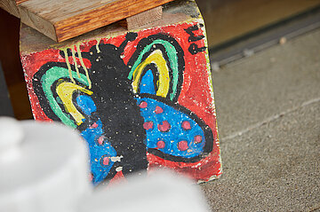 Gemalter, bunter Schmetterling auf einem Stein